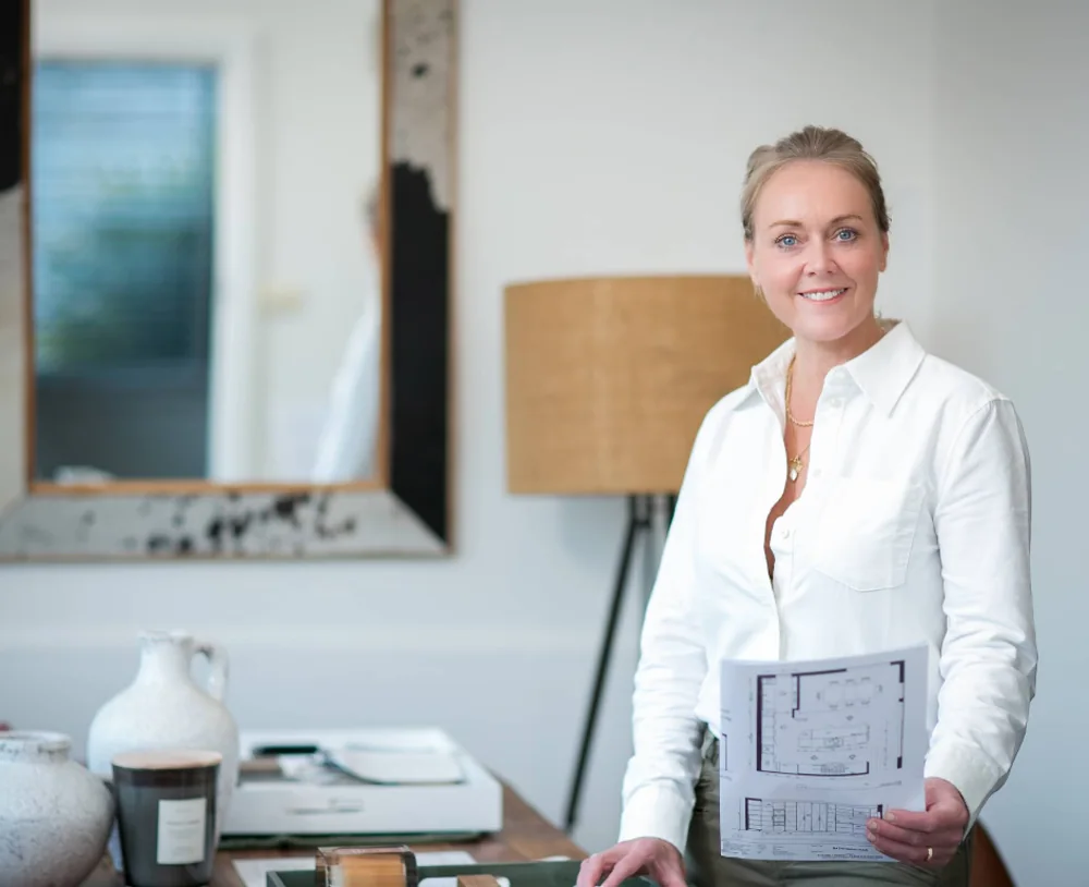 Sally Darkes in her studio, holding a set of floor plans